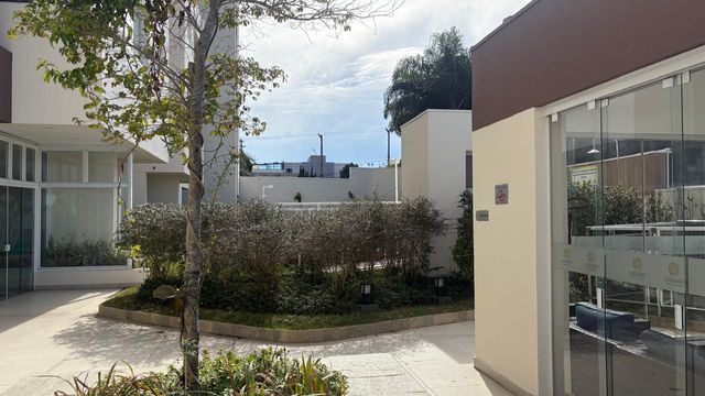 área externa do espaço gourmet envidraçado com churrasqueira a carvão e forno de pizza