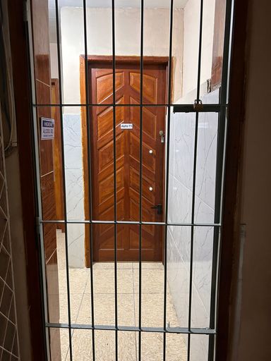 Portão com cadeado separando o corredor da entrada dos apartamentos T1 e T2