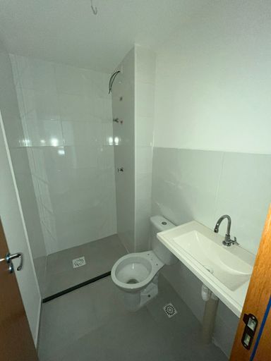 Banheiro elegante com bancadas em mármore sintético e revestimento cerâmico, unindo sofisticação e praticidade ao ambiente.