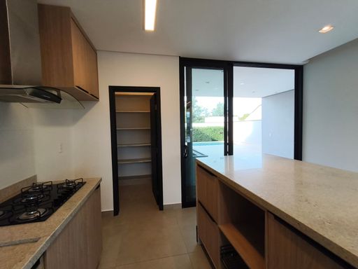 Vista da cozinha à despensa com prateleiras em granito