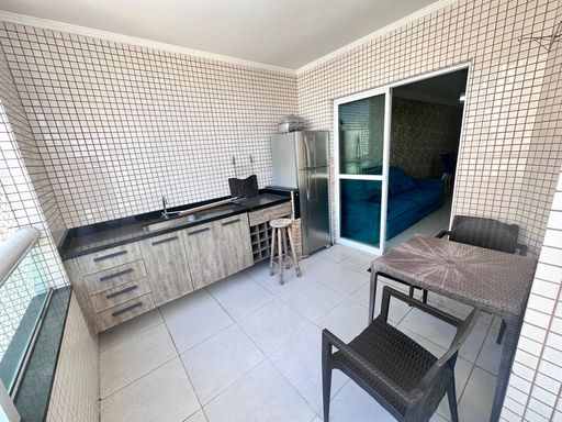 Sacada gourmet em L com geladeira e vista livre.