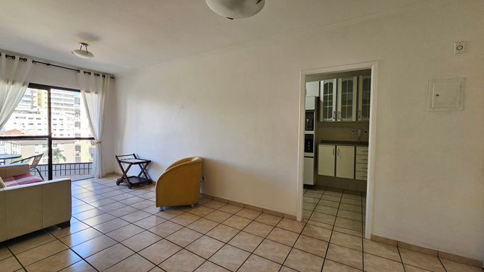 Sala de 2 ambientes com muita iluminação natural e um sofá.