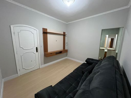 Sala com sofá e painel de TV.