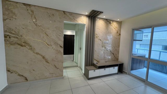 Sala de 2 ambientes com parede de mármore.