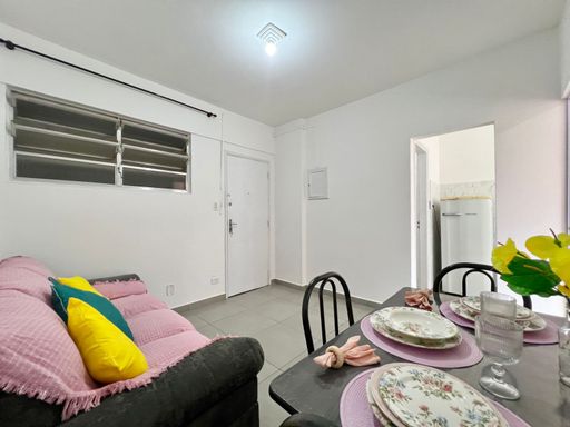 Sala com sofá de 3 lugares e mesa de jantar.