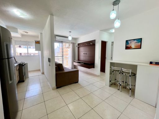 Sala bem iluminada de 2 ambientes com ar-condicionado e uma cozinha planejada.