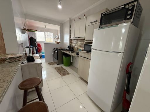 Cozinha americana planejada com fogão e geladeira branca.