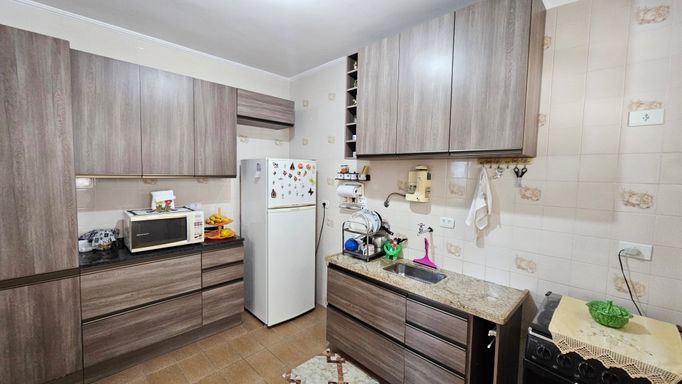 Cozinha com armários e uma geladeira.