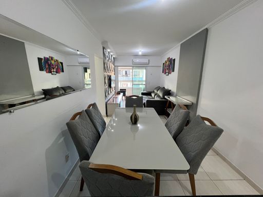 Sala de 2 ambientes com uma mesa de jantar, sofá e ar-condicionado.