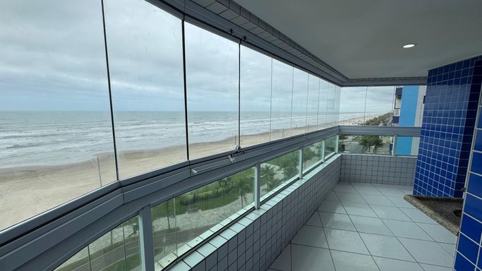 Sacada gourmet envidraçada com vista para o mar.