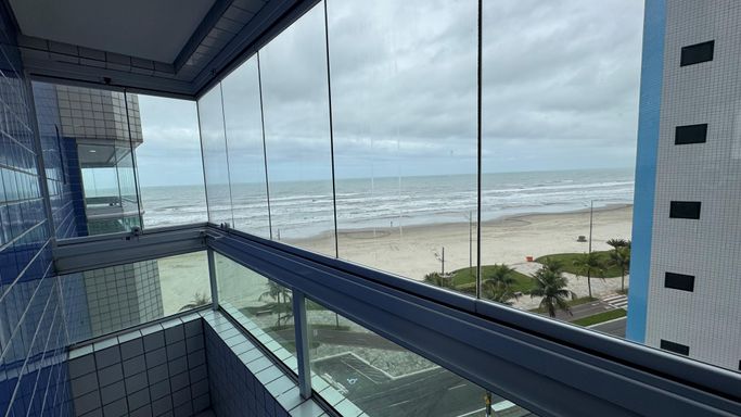 Sacada gourmet envidraçada com vista para o mar.