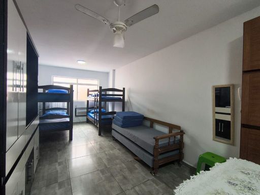 Sala living bem iluminada com ventilador de teto.