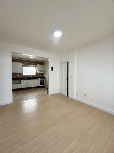 Sala bem iluminada com piso laminado.
