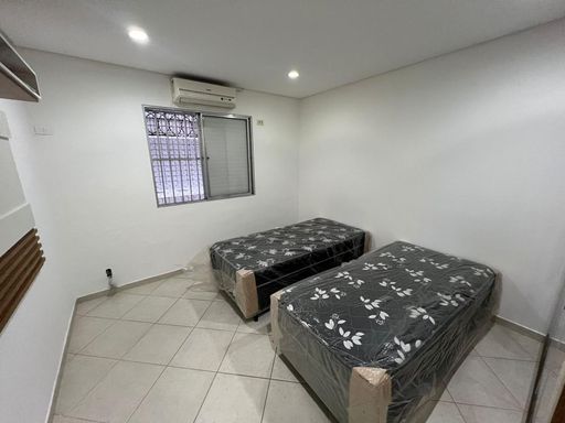 Dormitório com 2 camas de solteiro e ar-condicionado.