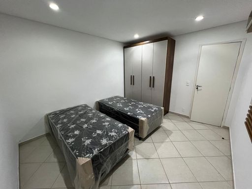 Dormitório com 2 camas de solteiro e armário planejado.