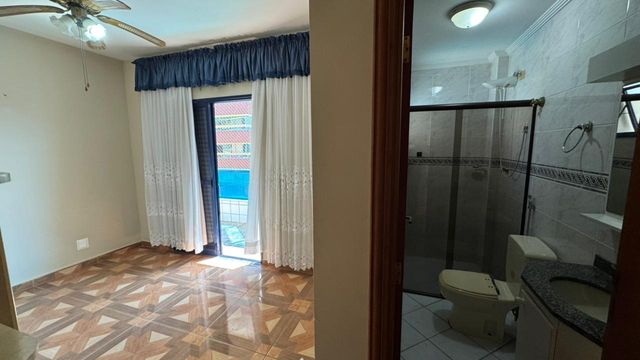 Suíte planejado com ventilador de teto e uma sacada privativa.