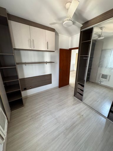 Suíte planejada com ar-condicionado de parede e ventilador de teto.