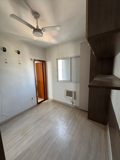 Suíte planejada com ar-condicionado de parede e ventilador de teto.