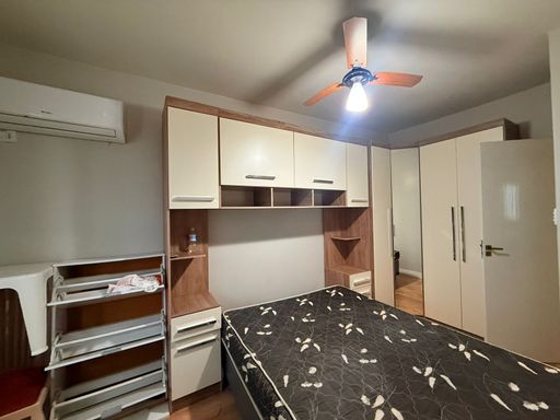 Dormitório com uma cama de casal, armários, e ar-condicionado.