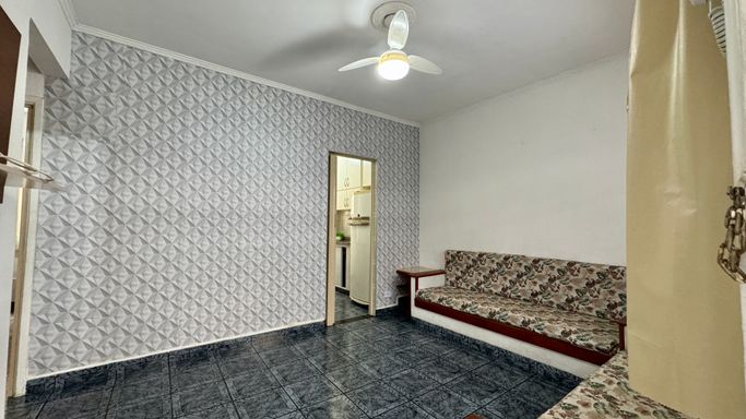 Sala bem iluminada, dois sofás embutidos e ventilador de teto.