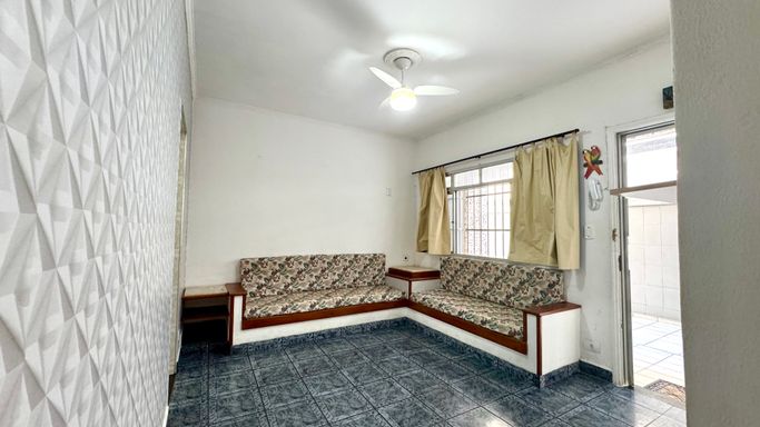 Sala bem iluminada, dois sofás embutidos e ventilador de teto.