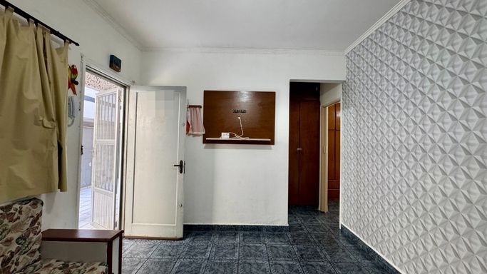 Sala bem iluminada, dois sofás embutidos e ventilador de teto.