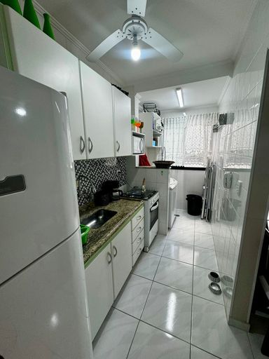 Cozinha com armários planejados, fogão e geladeira.