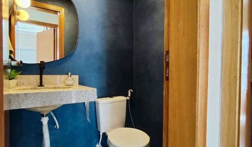 Lavabo com paredes azuis, pia e espelho.