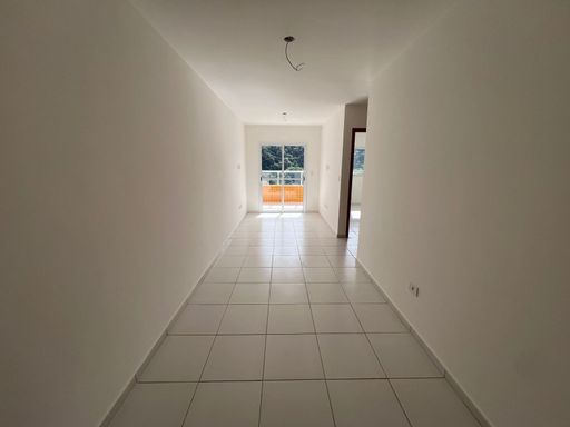 Sala de 2 ambientes com paredes brancas e iluminação natural.