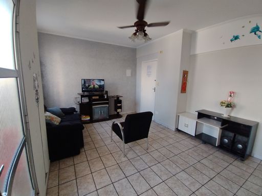Sala ampla e bem iluminada com ventilador de teto.