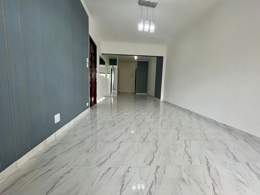 Sala bem iluminada de 3 ambientes com uma sacada envidraçada.