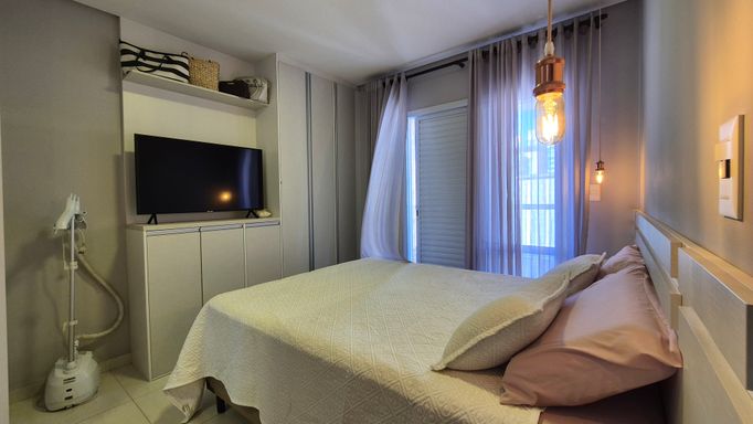 Suíte com armários planejados com uma sacada privativa.