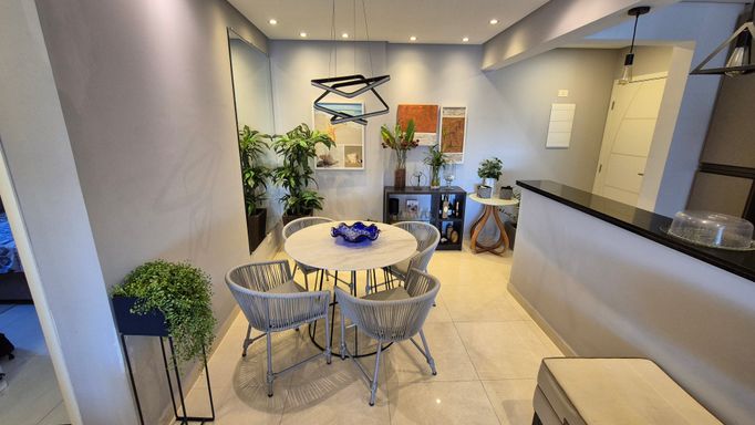 Sala de 2 ambientes com sofá e mesa de jantar para 04 pessoas.