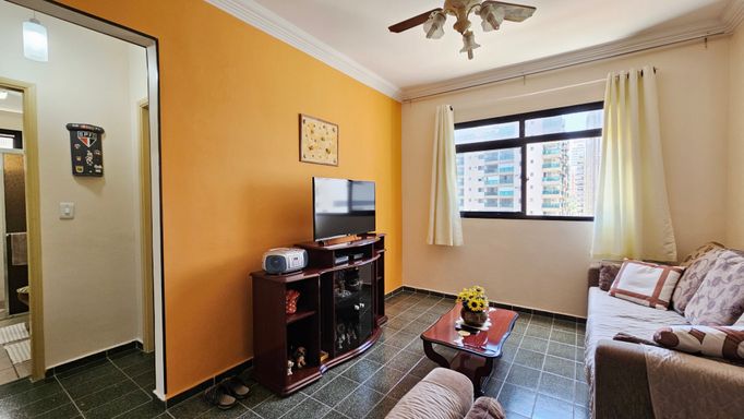 Sala ampla e bem iluminada com ventilador de teto e dois sofás.