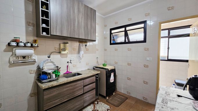 Cozinha com armários e uma geladeira.