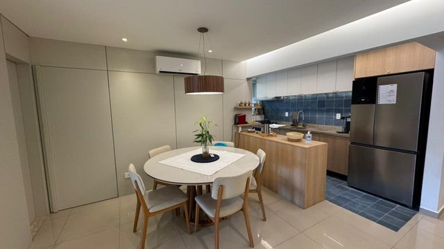 Sala ampla de 2 ambientes com um sofá, mesa de jantar e ar-condicionado.