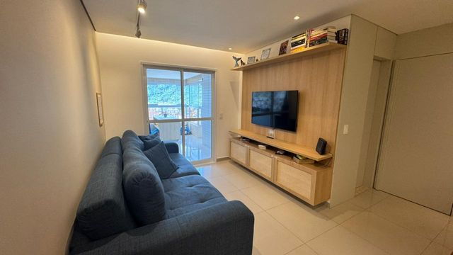 Sala ampla de 2 ambientes com um sofá, mesa de jantar e ar-condicionado.