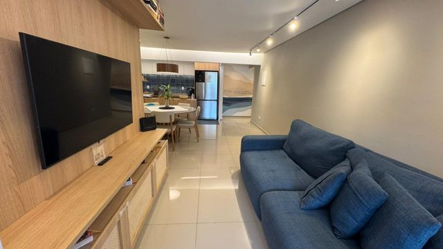 Sala ampla de 2 ambientes com um sofá, mesa de jantar e ar-condicionado.