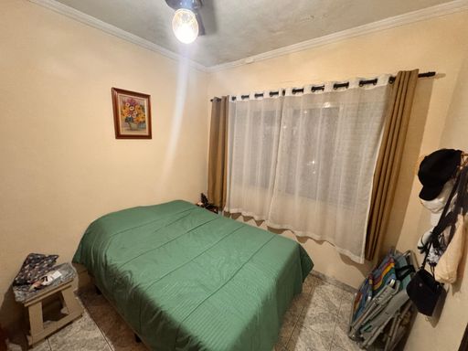 Dormitório com uma cama de casal e guarda-roupa.