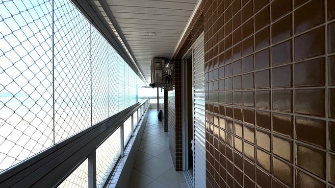 Sacada envidraçada com vista para o mar.