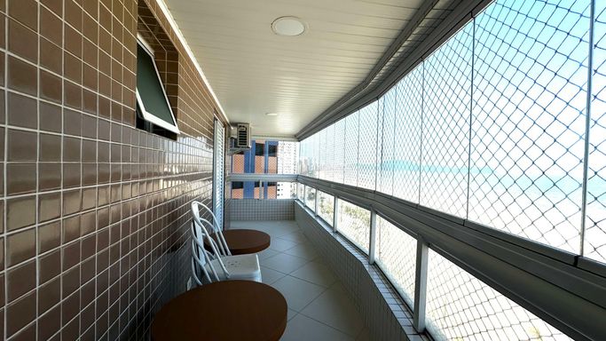 Sacada envidraçada com vista para o mar.