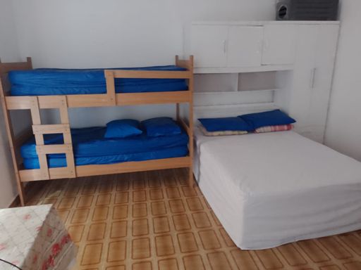 Sala living com uma cama de casal e beliche.