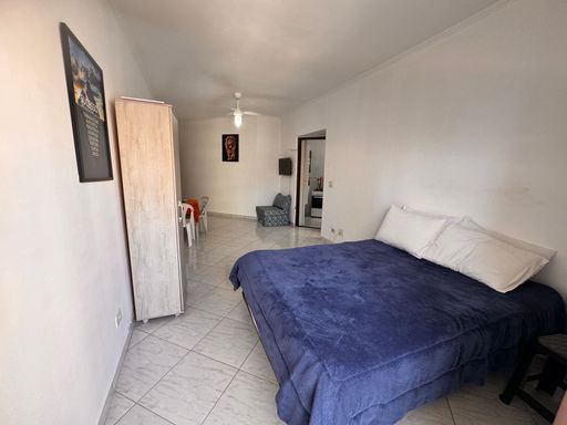 Sala living ampla e bem iluminada com uma sacada e ventilador de teto.