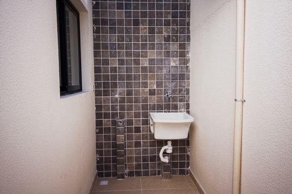 Área de serviço com um tanque branco.