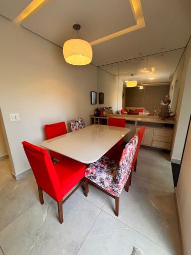 Sala de 2 ambientes com mesa de jantar e teto rebaixado em gesso com iluminação em LED e parede espelhada.
