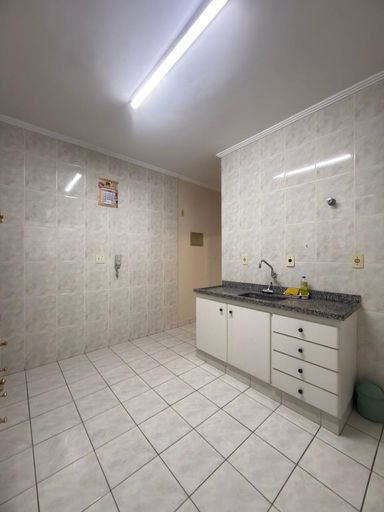 Cozinha com uma pia e gabinete e armários brancos.