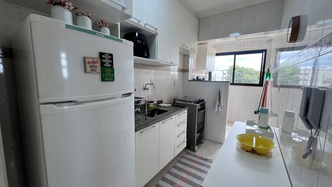 Cozinha planejada com uma geladeira branca e fogão.