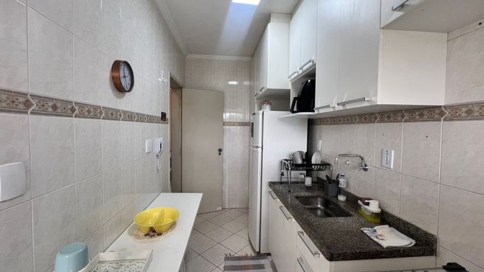 Cozinha planejada com uma geladeira branca e fogão.