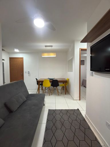 Sala com uma mesa de jantar e sofá cama.