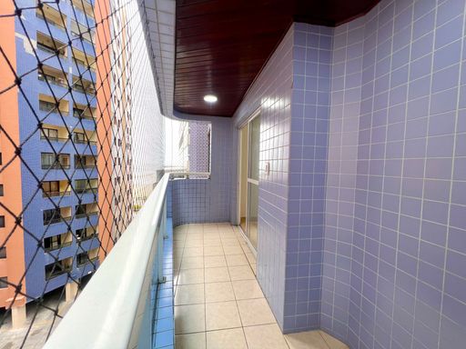 Sacada gourmet com churrasqueira a carvão com vista para o mar.